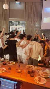 צעירים רוקדים ושרים ליד שולחן ארוך באירוע