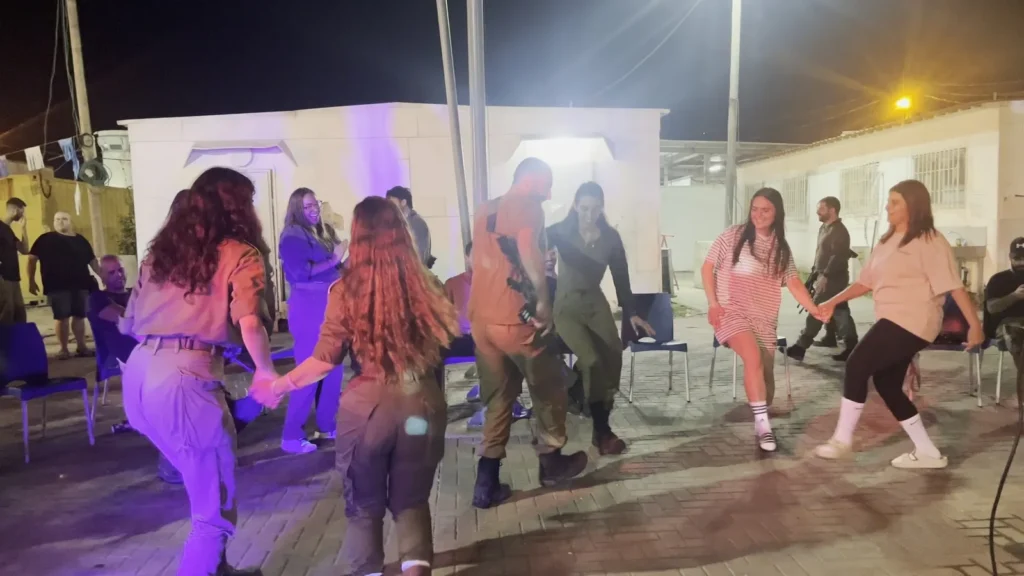 צעירים רוקדים במעגל בערב בחוץ