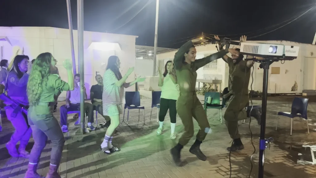 חיילים וחיילות רוקדים בערב גיבוש בחוץ