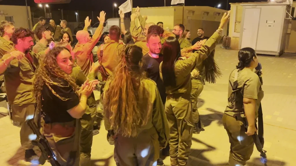 חיילים וחיילות רוקדים ומרימים ידיים בערב גיבוש