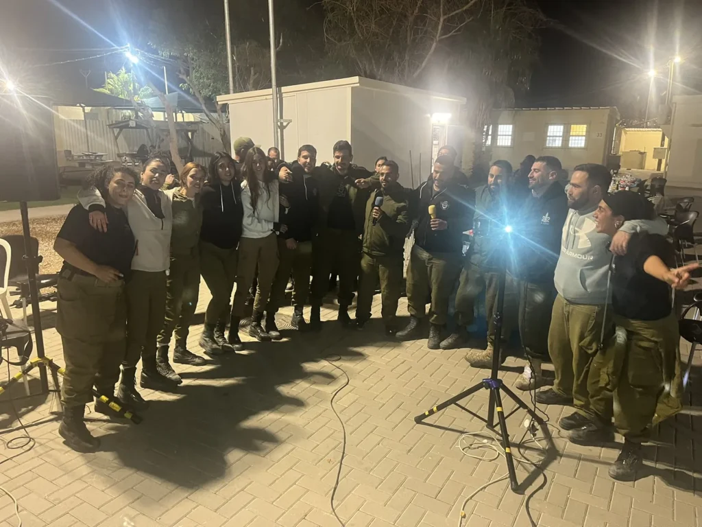 חיילים וחיילות שרים מחובקים במעגל בערב קריוקי