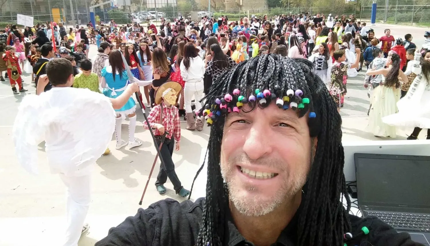 ארז מצטלם מול רחבה מלאה בילדים בהפעלה בבית ספר
