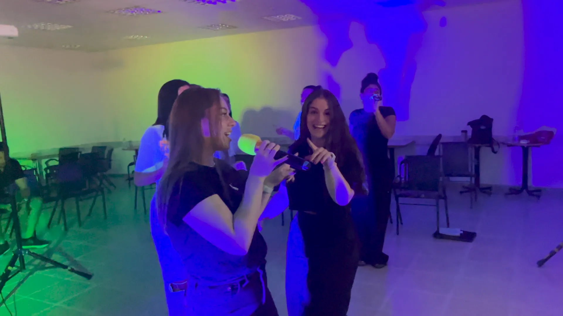 שתי חברות שרות דואט במיקרופון וצוחקות
