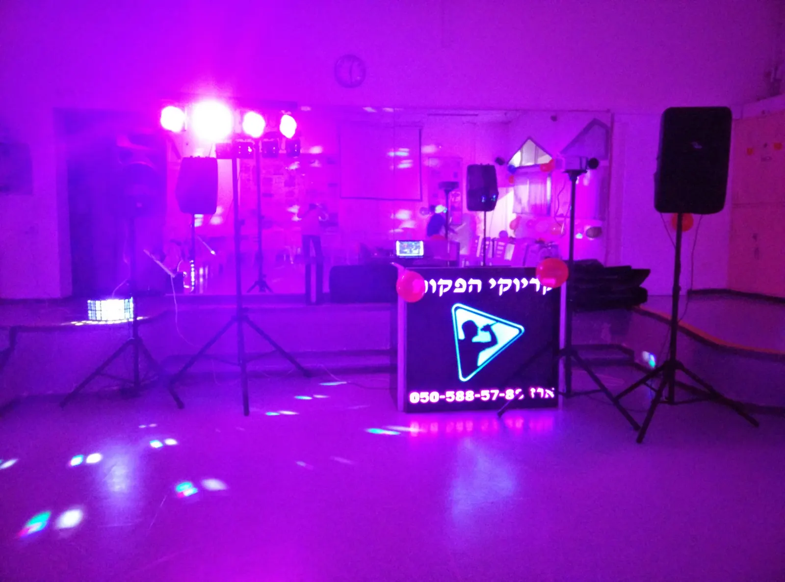 עמדת קריוקי של ארז כץ מוכנה לאירוע: מסך, רמקולים ותאורה סגולה