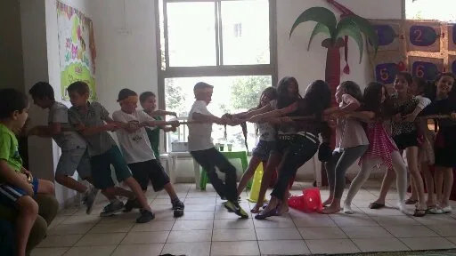 ילדים במשחק משיכת חבל בהפעלה בגן